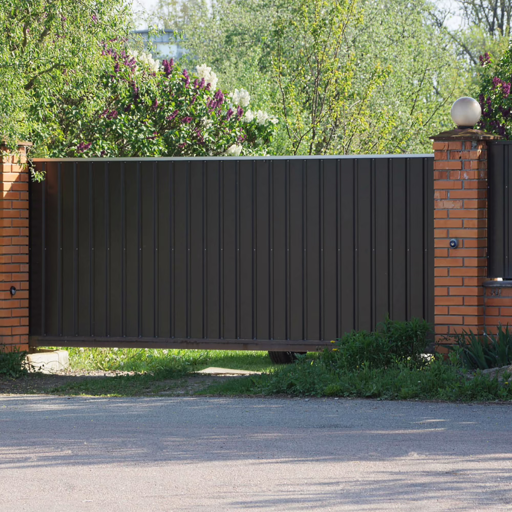 one brown gate and part of the fence of bricks and metal in the