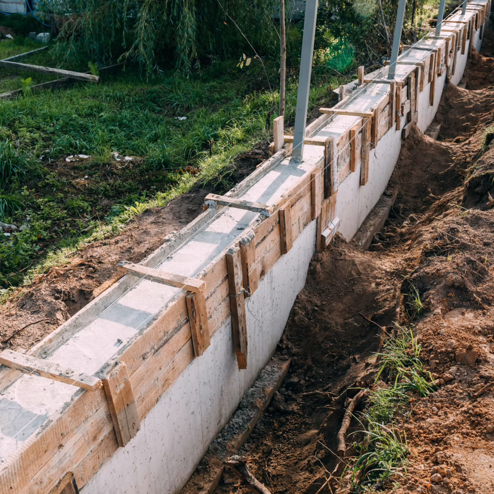 Timber formwork with metal reinforcement with pour concrete and creating a solid foundation for a building or fence. Construction process. Building the retaining wall. Side view. Nobody. Copy space